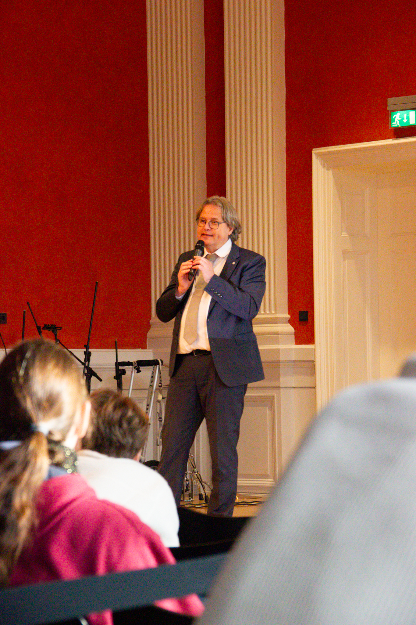 Stefan Weih spricht auf der Bühne der Aula in ein Mikrofon