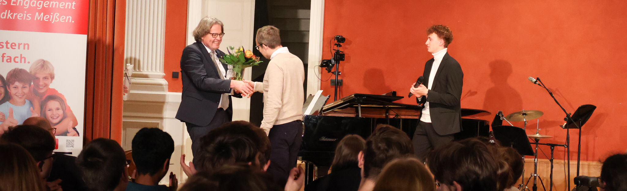 Schulleiter Stefan Weih übergibt plus-MINT Geschäftsführer Sven Meier einen Blumenstrauß